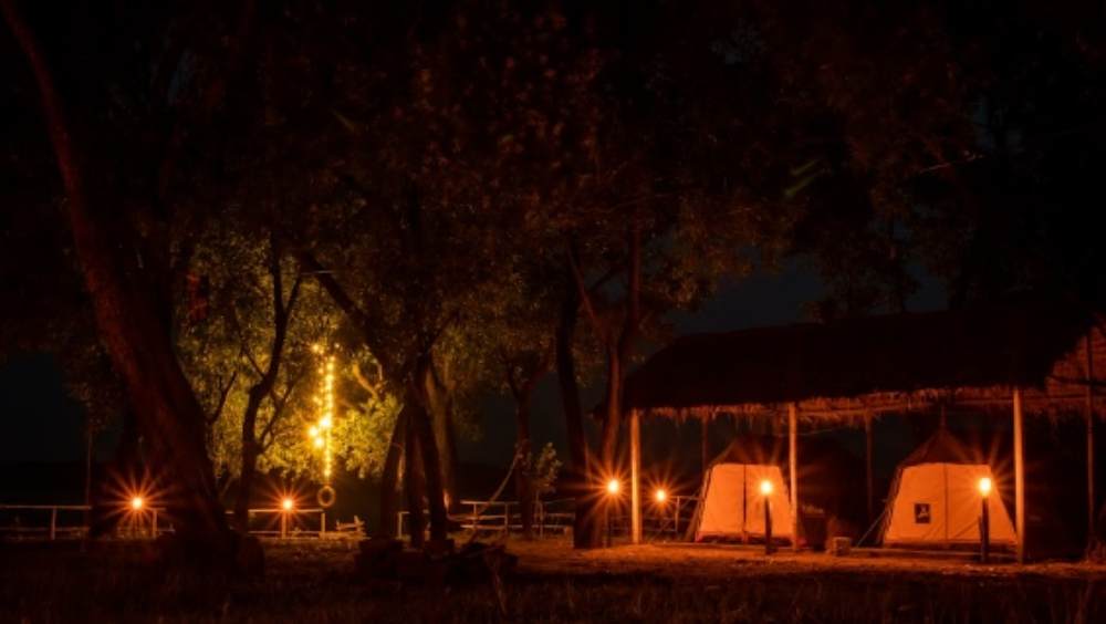 দোলাডাঙা ব্যাকপ্যাকার্স ক্যাম্প: পুরুলিয়ার আদিবাসী গ্রাম দোলাডাঙা। লাল মাটির পথ পলাশ বনের মধ্যে দিয়ে যেখানে পৌঁছয়, সেখানে জঙ্গল আর হ্রদের নিঃশব্দ সহাবস্থান। এখানেই কাটিয়ে ফেলতে পারেন এ বারের অ্যাডভেঞ্চার সফর। ক্যাম্পফায়ারে শালপাতা চিকেন আর বিশাল হ্রদ। প্রকৃতিপ্রেমী মনের রসদ একরাশ প্রশান্তি। কলকাতা থেকে এখানকার দূরত্ব প্রায় ২৩৬ কিলোমিটার। থাকা, খাওয়া ও ক্য়াম্প ফায়ার নিয়ে মাথাপিছু খরচ পড়বে ১২০০ থেকে ১৪০০ টাকা। ছবি ও তথ্য সৌজন্যে: ইজিফিসো ব্যাকপ্যাকার্স। 