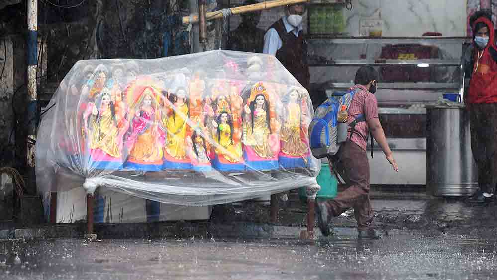 সকাল থেকে আকাশের মুখ ভার। বৃষ্টি থেকে বাঁচাতে সরস্বতী প্রতিমায় প্লাস্টিকের আবরণ। শুক্রবার শহরে।