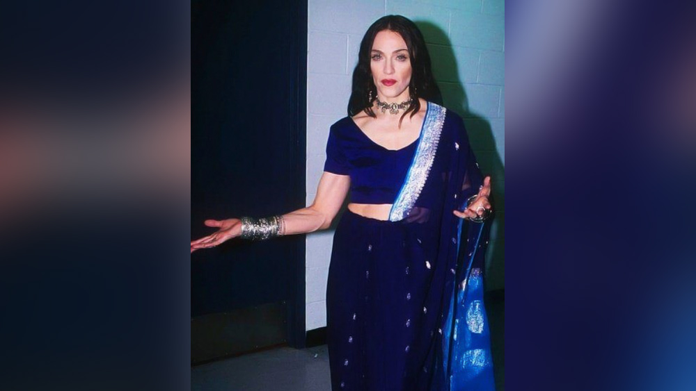 ম্যাডোনা: ব্রিটনি স্পিয়র্সকে যদি পপ সঙ্গীতের রাজকুমারী নামে ডাকা হয় তবে ম্যাডোনা ভক্তরা তাঁকে ডাকেন পপ সঙ্গীতের রানী হিসেবে। বিরল হলেও ভারতীয় ভক্তদের জন্য কিন্তু ম্যাডোনা একবার হলেও ধরা দিয়েছেন একেবারে ধ্রুপদী নীল শাড়িতে।