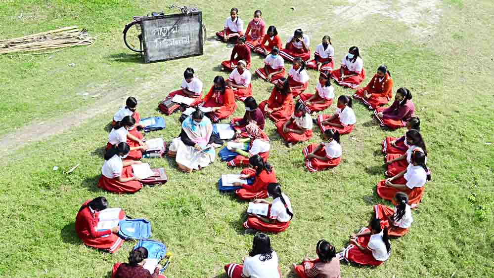 বাগনানের মুগকল্যাণ গার্লস হাইস্কুল থেকে কিছুটা দূরের একটি মাঠে পড়ুয়াদের নিয়ে চলছে ‘পাড়ায় শিক্ষালয়’। সোমবার । 