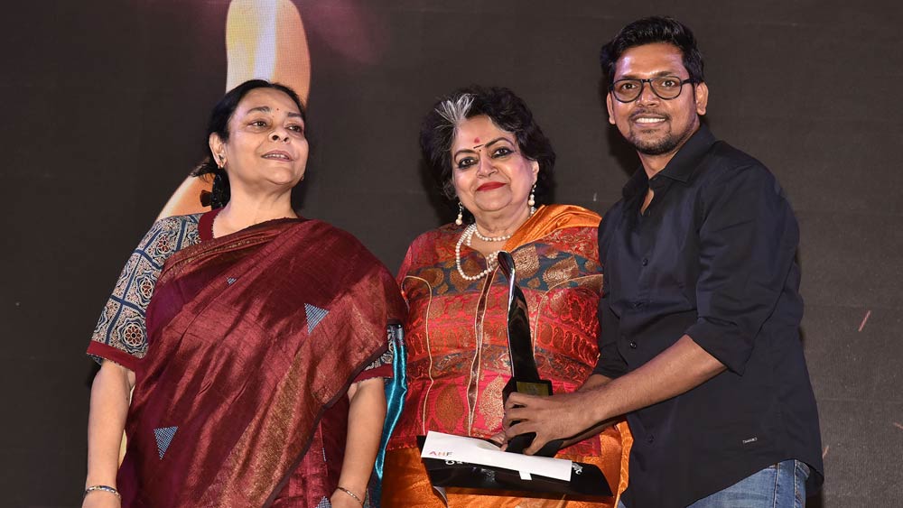 শ্রেয়সী চট্টোপাধ্যায় এবং অল্কা পাণ্ডের হাত থেকে পুরস্কার নিচ্ছেন আশিস। 