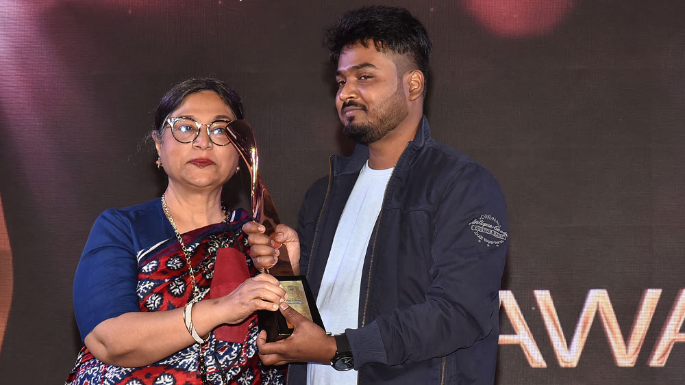 শিল্পী জয়শ্রী বর্মণের হাত থেকে পুরস্কার নিচ্ছেন অক্ষয়। 
