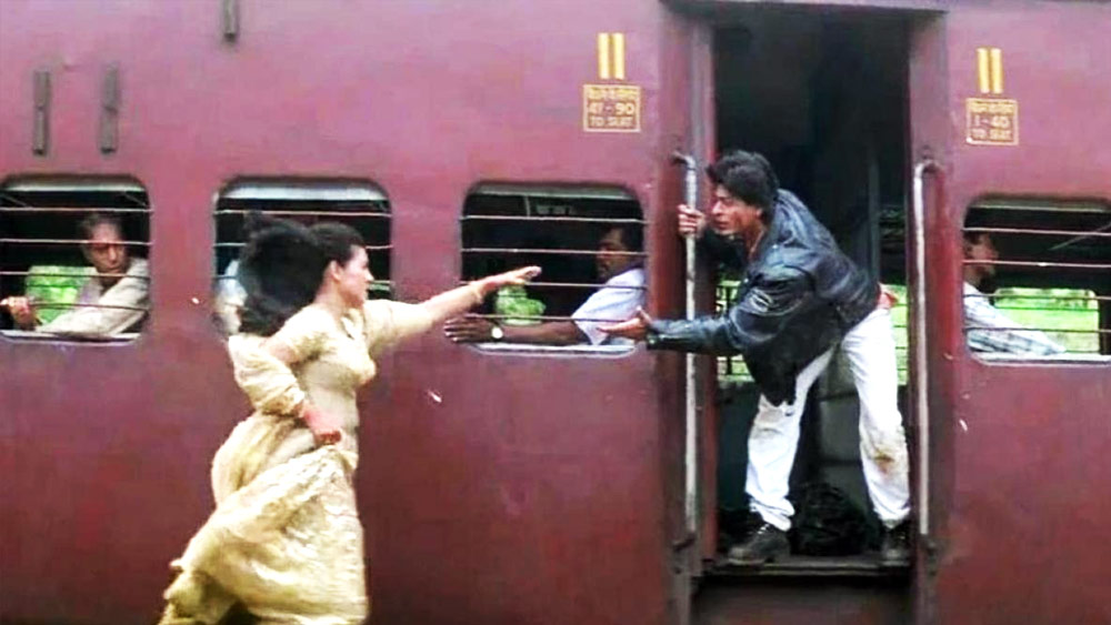 নতুন প্রজন্মের কাছে সংক্ষেপে ‘ডিডিএলজে’। তবে ছবির নামের মতো রাজ-সিমরনকে ছেঁটে ফেলতে পারেননি বহু দর্শক। তাঁদের কাছে আজও বলিউডি প্রেমের শেষ কথা— রাজ-সিমরন থুড়ি শাহরুখ খান এবং কাজলের জুটি। ‘ডিডিএলজে’-র শেষ দৃশ্য কখনও ভোলা যায়! সিমরনের বিয়ের ঠিক আগে তাঁর বাড়িতে হাজির রাজ। খুনসুটির মাঝেই কখন যে প্রেম গাঢ় হয়েছে, তা বুঝতে পেরেছেন। তবে প্রেমিকার বিয়ে তো স্থির। অবশেষে রাজের বিদায়ের পালা। তবে সিমরনের থেকে দূরে গিয়েও সরে যেতে পারলেন না। বিয়ে ফেলে স্টেশনে ছুটে গিয়েছেন সিমরনও। শেষে চলন্ত ট্রেনের দরজায় দাঁড়ানো রাজের বাড়ানো হাতে নিজের হাত এগিয়ে দিয়েছেন।