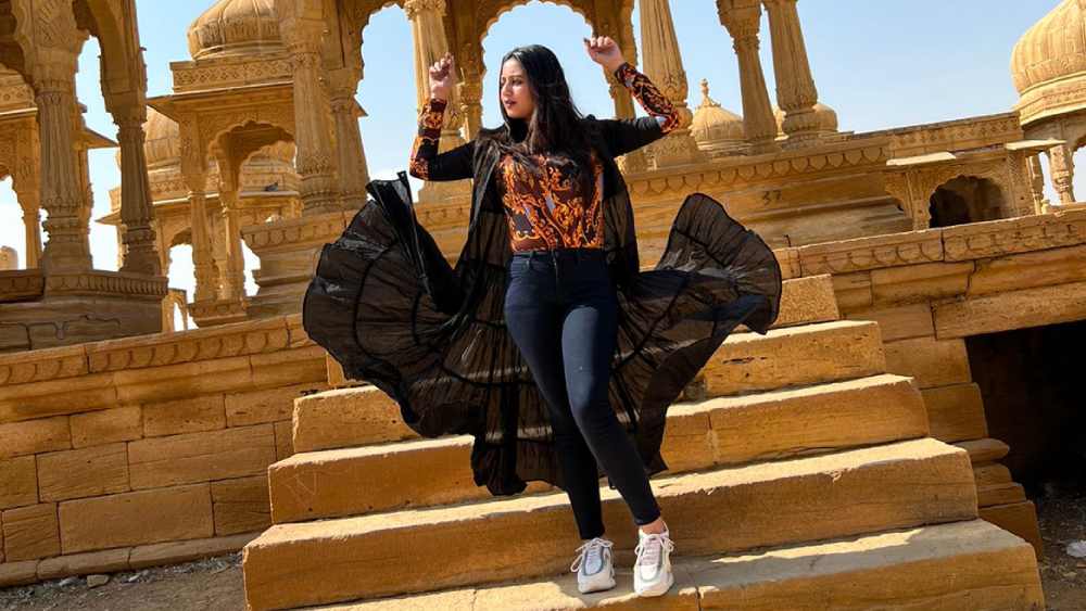 লম্বা ঝুলের শ্রাগ, রংবাহারি টপ, খোলা চুল—  মরুদেশে বোহেমিয়ান সাজ বেছে নিয়েছেন স্বস্তিকা। নজর কেড়েছে তাঁর পায়ের ধবধবে সাদা স্নিকার। 