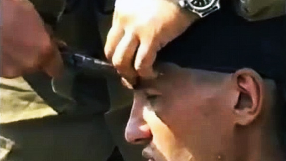 যিনি বুলেটবিদ্ধ, তিনি একেবারেই নির্বিকার। হাসিমুখেই ক্যামেরার সামনে মুখ ঘোরাচ্ছেন। এতেই শেষ নয়। সেনায় তাঁর সঙ্গীরা একটি প্লায়ার্স দিয়ে ওই বুলেটটি টেনে বার করে নিচ্ছেন।