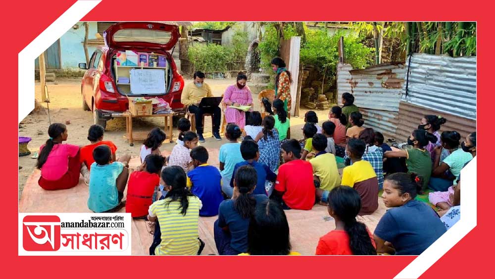 লাল রঙের ছোট্ট গাড়িটার পিছনের দিকে তাকে-সাজানো বই। সবই স্কুল-কলেজের পাঠ্য। আর সঙ্গে স্যানিটারি ন্যাপকিন। এই গাড়ি নিয়েই উত্তরবঙ্গের বিভিন্ন জায়গায় ঘুরে বেড়ান তরুণ দম্পতি।