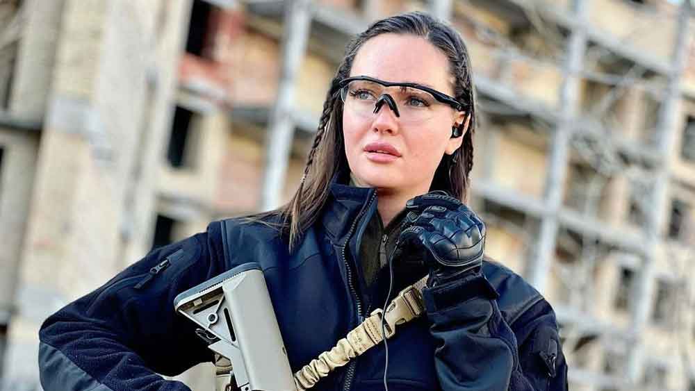 Fake News: আঁটো করে বাঁধা পনিটেল। উঁচু হিলজোড়ার বদলে পায়ে সেনানির বুট। পরনে লেদার জ্যাকেট। হাতে মারণাস্ত্র। নেটমাধ্যমে আজকাল এ সাজেই দেখা যাচ্ছে প্রাক্তন ‘মিস ইউক্রেন’-কে।