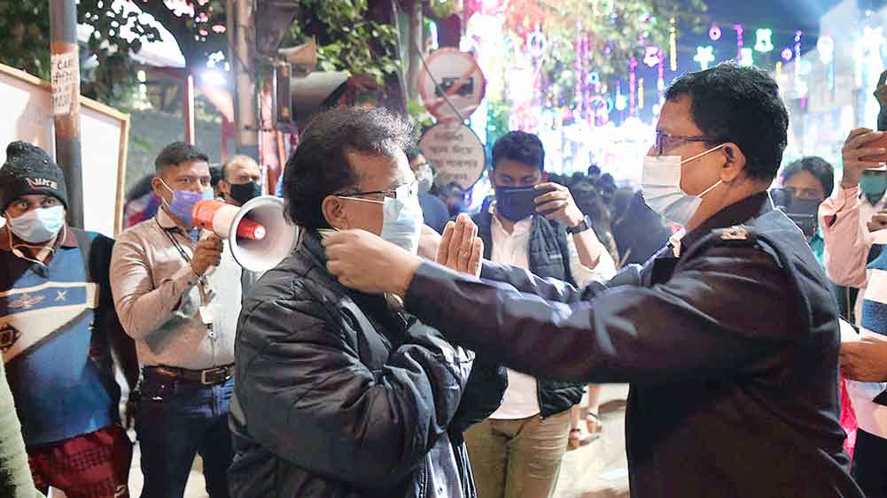 পার্ক স্ট্রিটে মানুষকে মাস্ক পরাচ্ছে পুলিশ। । 