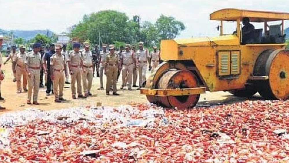 মদের বোতল ভেঙে গুঁড়িয়ে দিচ্ছে পুলিশ।