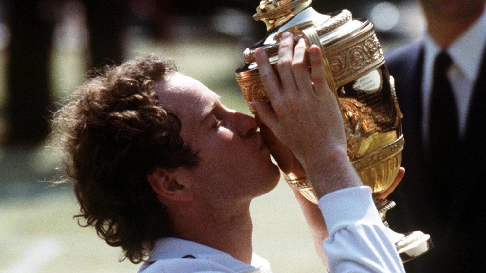 বিজেতার ট্রফি হাতে ম্যাকেনরোর ছবি ছাপিয়েও ভেসে ওঠে টেনিস কোর্টে র‌্যাকেট ভাঙার দৃশ্য কিংবা চেয়ার আম্পায়ারের সঙ্গে তুমুল তর্ক জুড়ে দেওয়া উদ্ধত এক রাগী মুখ। 