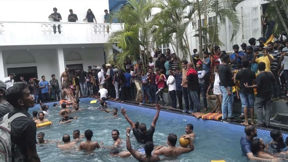 প্রেসিডেন্টের প্রাসাদে একাধিক সুইমিং পুল। গোতাবায়া পালিয়েছেন ঠিকই, কিন্তু বাড়ির দরজা খুলে রেখে। দু’দিন আগে যে সুইমিং পুলে গা ভাসাতেন দেশের প্রেসিডেন্ট, আজ সেই তরঙ্গে মিশেছে জনসাধারণের বারোয়ারি বপু। 