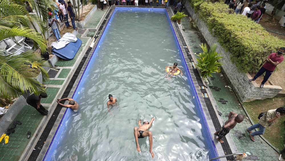 শনিবারই আন্তর্জাতিক সংবাদ সংস্থার ক্যামেরায় ধরা পড়েছিল, প্রেসিডেন্টের প্রাসাদের সুইমিং পুল ব্যবহার করছে সাধারণ মানুষ। রবিবারও তার অন্যথা হল না। অনেকে প্রাসাদে ঢুকেই ডুব মারলেন সুইমিং পুলে। 