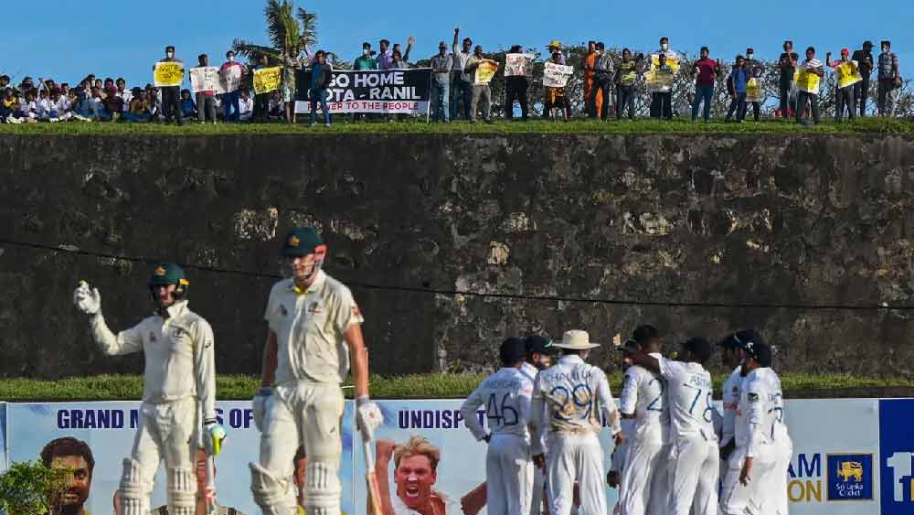 খেলার মাঠে প্রেসিডেন্টের পদত্যাগ চেয়ে পোস্টার হাতে দর্শক। 