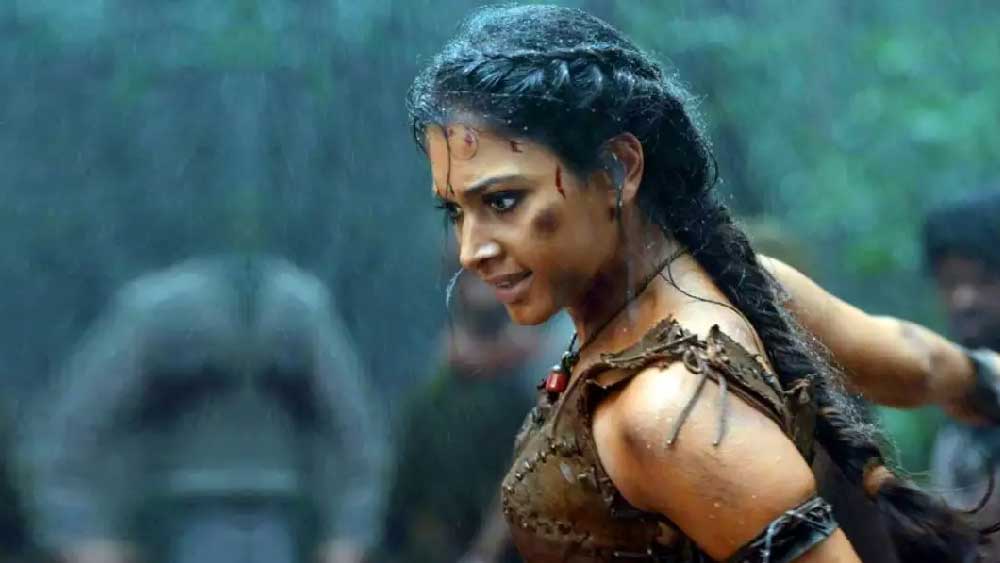 ক্যামেরার দিক পরিবর্তন হতেই দেখা যায়, মুহূর্তের মধ্যে ওই টপের পিছনে বেগুনি ফিতে দিয়ে নটের মতো বাঁধা রয়েছে।