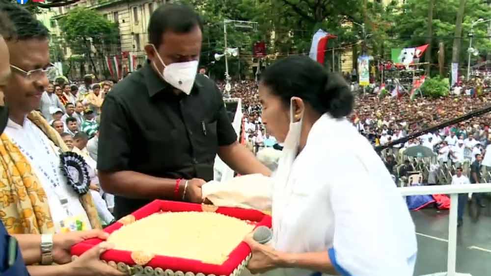মুড়ি: ২১ জুলাইয়ের মঞ্চে ভাষণ দিতে গিয়ে মমতার মুখে উঠে আসে মুড়িতে জিএসটি বসানোর প্রসঙ্গ। জনতার কাছ থেকে মুড়ি চেয়ে নেন মমতা। সেই মুড়ি দেখিয়ে বিজেপিকে প্রশ্ন করেন, ‘‘মুড়িতেও জিএসটি! খাব কী? মানুষ খাবে কী? বিজেপির বন্ধুরা মুড়ি খাবেন না?’’ মমতা স্লোগান তোলেন, ‘‘আমাদের মুড়ি ফিরিয়ে দাও, নইলে বিজেপি বিদায় নাও।’’ 