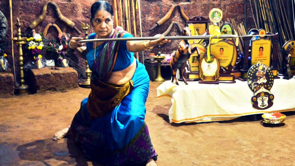 তরবারি হাতে এই বৃদ্ধার নাম মীনাক্ষী আম্মা। বয়সে তিনি অশীতিপর। কিন্তু কাজে আঠারো। দৃপ্ত চেহারার মীনাক্ষী ভারতীয় মার্শাল আর্টে মহিলাদের ফিরিয়ে আনছেন।