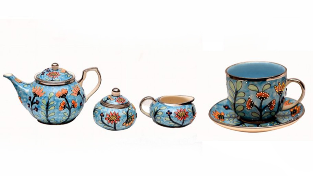 উত্তরপ্রদেশের বুলন্দশহর জেলা বিখ্যাত হাতে এঁকে নকশা করা বিভিন্ন জিনিসপত্রের জন্য। সেই শিল্পকর্মই ব্রিটেনের প্রধানমন্ত্রী বরিস জনসনকে উপহার দিয়েছেন প্রধানমন্ত্রী মোদী। প্ল্যাটিনাম রঙের উপর হাতে নকশা করা একটি চায়ের কাপ-প্লেট এবং কেটলির সেট উপহার দিয়েছেন তিনি। ব্রিটেনের রানি এলিজাবেথের দ্বিতীয়-এর সিংহাসনে বসার ৭০ বছর পূর্তিকে সম্মান জানাতেই এই বিশেষ রঙের কাপ-প্লেটের সেটটি উপহার দেওয়া হয়েছে বলে সূত্রের খবর। 