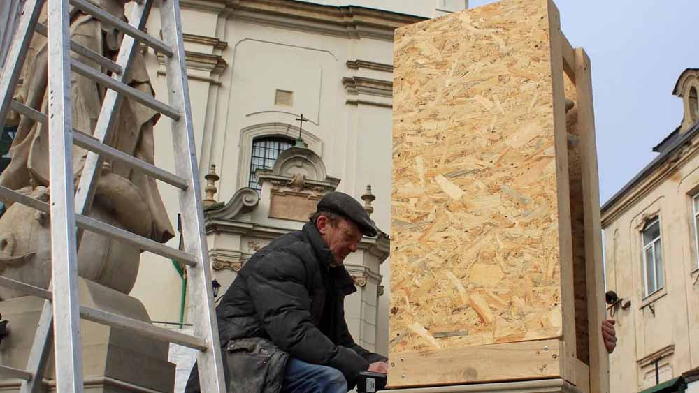 লুভিভের সেন্ট অ্যান্টনি চার্চের সামনেই রয়েছে অপরূপ একটি মূর্তি। তা ঢাকতে কাঠের বাক্সের ফ্রেম তৈরি করেছেন স্থানীয়েরা। কাঠের মূর্তির চারপাশে ওই ফ্রেম বসিয়ে তা কাঠের টুকরো দিয়ে আপাদমস্তক ঘিরে ফেলা হয়েছে। 
