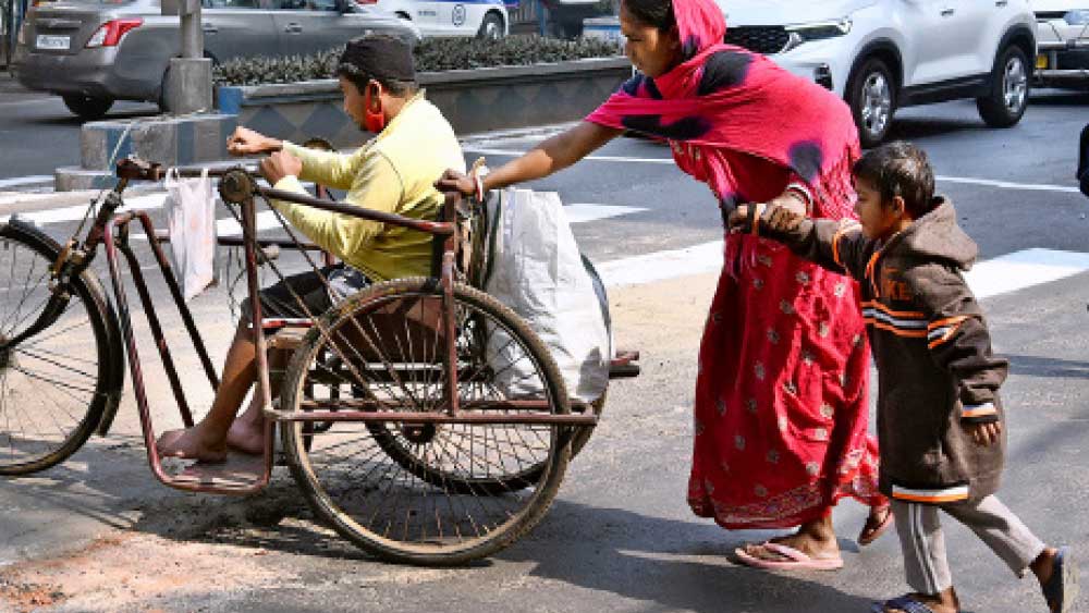 n নারীশক্তি: এক হাতে ধরা সন্তানের হাত। অন্য হাতে এগিয়ে নিয়ে চলেছেন স্বামীকে। আজ, মঙ্গলবার আন্তর্জাতিক নারী দিবসের আগে শহরের পথে।  