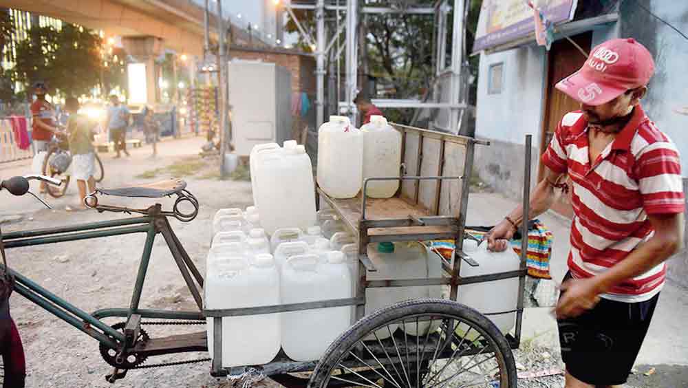 জল-যান: বিক্রির জন্য তোলা হচ্ছে পানীয় জলের জার। বাইপাসের কাছে। 