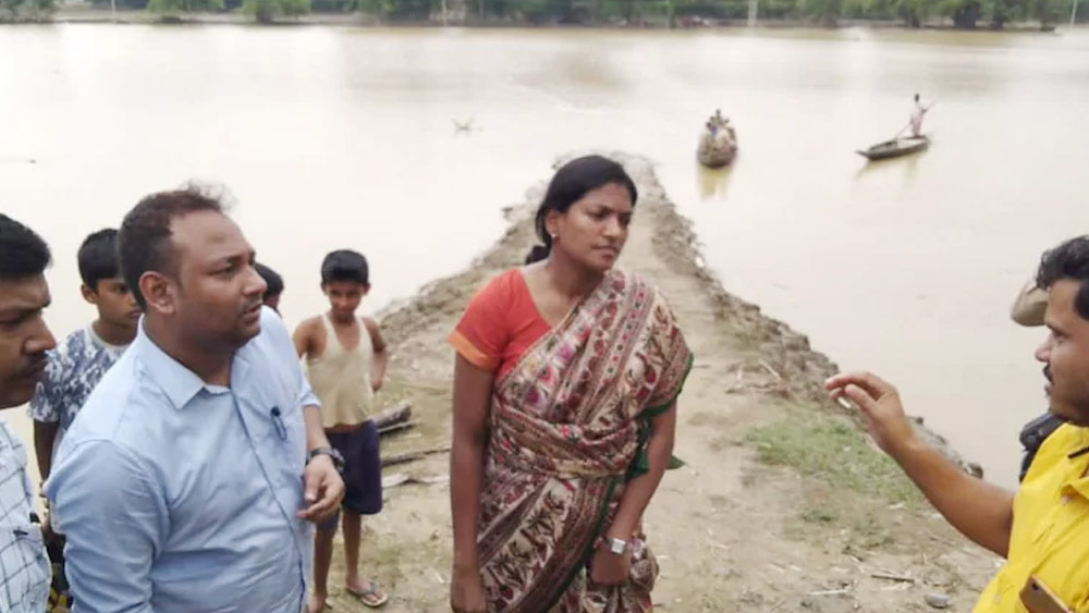 পরনে সাধারণ একটা শাড়ি, আঁচলটা কোমরে গোঁজা। বাঁ হাতে একটা ঘড়ি। কিছু ক্ষণ পর পর চোখ রাখছিলেন ঘড়ির ডায়ালে। হাঁটার গতি বাড়ালেন। এ বার খালি পায়ে এগিয়ে গেলেন জলবন্দি মানুষদের কাছে। সমব্যথী হয়ে তাঁদের পাশে দাঁড়ালেন আইএস অফিসার কীর্তি জাল্লি।