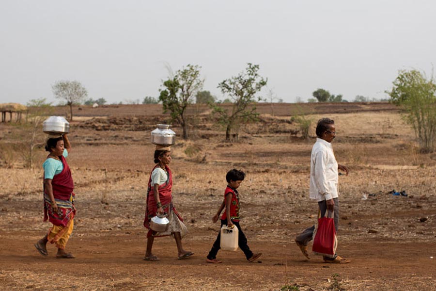 শুকনো নদীর সামনে থাকা পাথরের ফাটল থেকে গ্রামের গৃহবধূদের জল ভরতে হয়। নদীর ধারে থাকা পাথরের ফাটলে হাত ঢুকিয়ে একটি বাটি দিয়ে সেই জল তুলে পাত্রে ভরতে হয় তাঁদের।