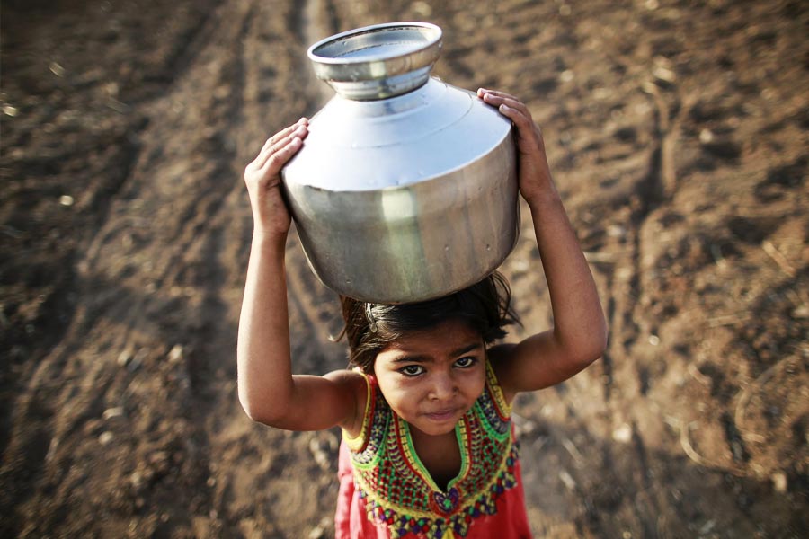 খাড়াই রাস্তা ধরে মাথায় দু’টি কলসি এবং হাতে টর্চ জ্বেলে বাড়ি ফেরেন গ্রামের মহিলারা। শুধু জল ভরতে যাওয়া নয়, বাড়ির অন্যান্য কাজও করতে হয় মহিলাদেরই।