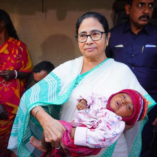 শিশুকে কোলে নিয়ে মমতা বন্দ্যোপাধ্যায়।