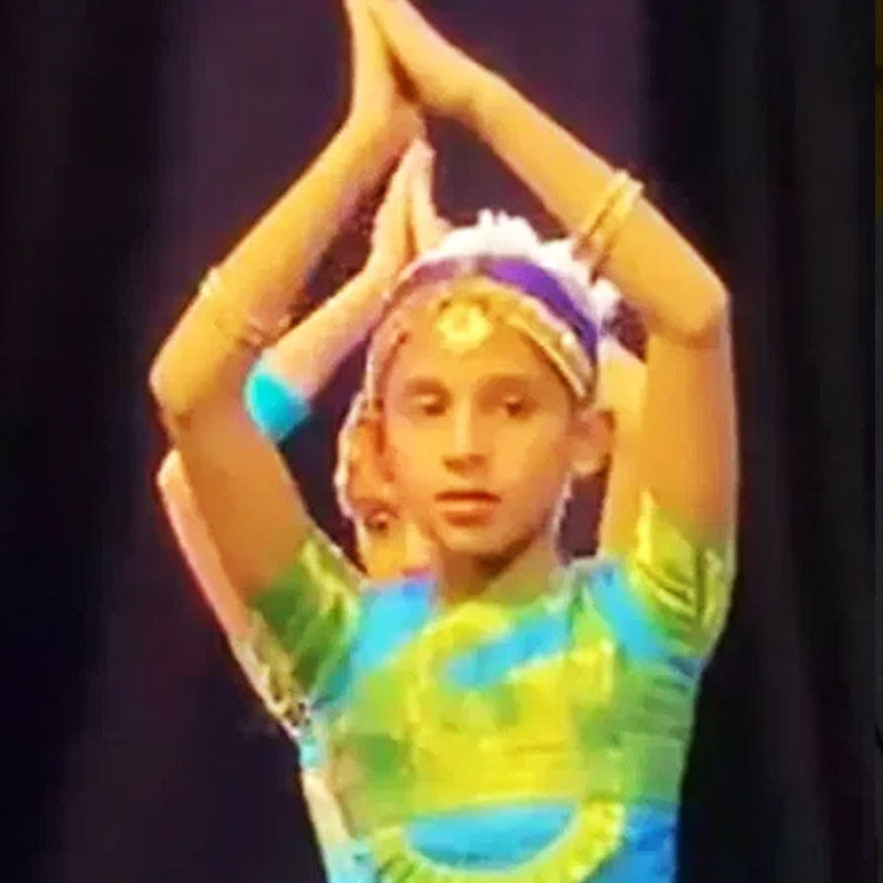 স্টেজের উপর সামনের সারিতে দাঁড়িয়ে গানের তালে তালে দিব্যি নাচছে ছোট্ট মেয়ে। পরনে শাড়ি, মাথায় জড়ানো সাদা ফুলের মালা। প্রথম দেখায় বোঝার উপায় নেই, এই খুদে নৃত্যশিল্পী ইংল্যান্ডের প্রধানমন্ত্রীর মেয়ে।