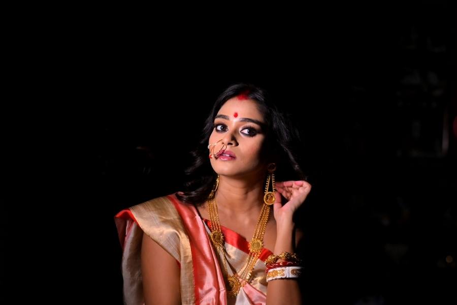 সাদা-লাল রঙের গরদ। শ্রীতমা দে-র শাড়ির সোনালি পাড়ে জমে এক চিলতে উৎসব। খোলা পিঠে মিশেছে তারই রেশ। 