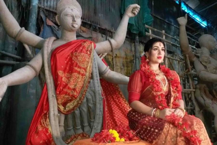 পরনে লাল কাপড়, মাথায় রক্ত বর্ণা জবা, গলায় জবার মালা আর কপালে আঁকা ত্রিনয়ন। ঠোঁটের কোণে লেগে রয়েছে হাসি। যেন মায়েরই শান্ত রূপ। 