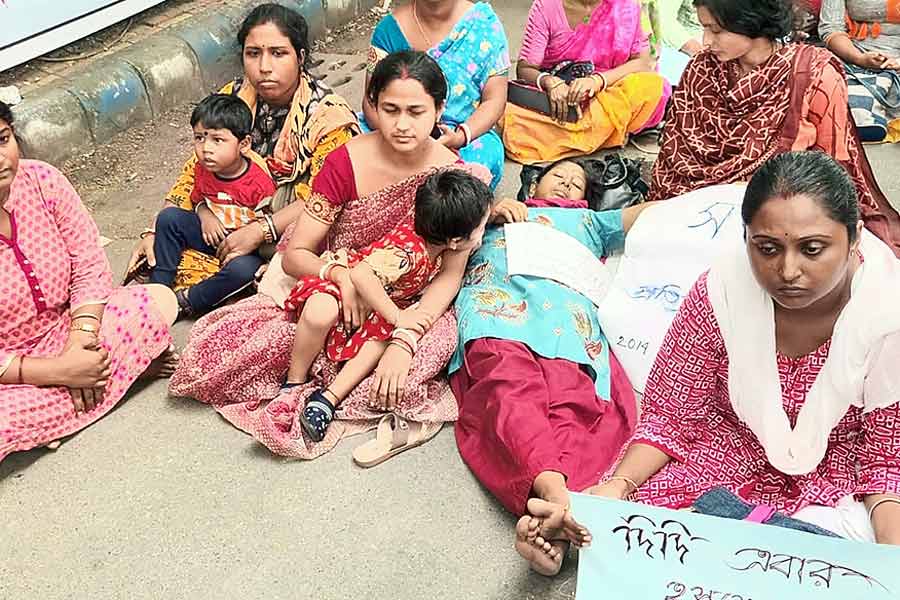 অবিচল: সন্তানকে সঙ্গে নিয়েই হোক বা বাড়িতে রেখে, চাকরির দাবিতে লড়াইয়ের মঞ্চ ছাড়তে নারাজ এই মায়েরা। বৃহস্পতিবার, করুণাময়ীতে। নিজস্ব চিত্র।