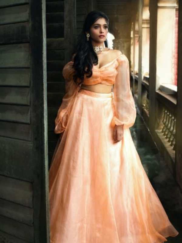 প্যাস্টেল রঙা বেলুন স্লিভস টপ, সঙ্গে একই রঙের ফ্লেয়ার স্কার্ট। একরাশ চুল কাঁধের একপাশ থেকে নেমে এসেছে বুক বরাবর। 