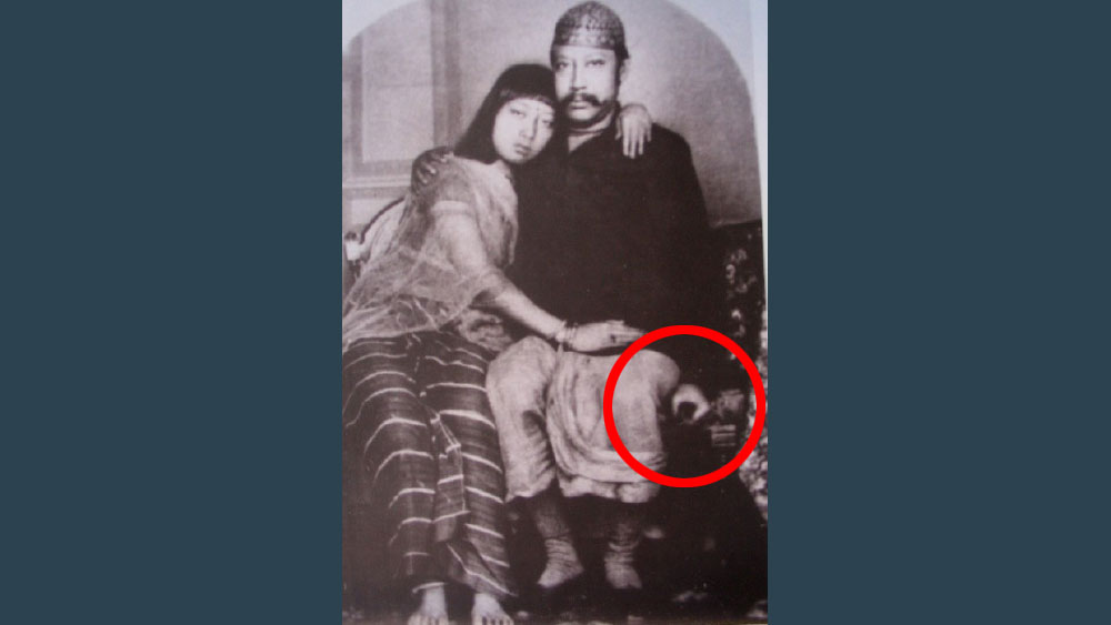 এই ছবি ভাল করে দেখলে দেখা যাবে, রাজা বীরচন্দ্র নিজের বাঁ হাতে কিছু একটা চেপে ধরে আছেন। দেখে মনে হবে ছোট কোনও যন্ত্র। 