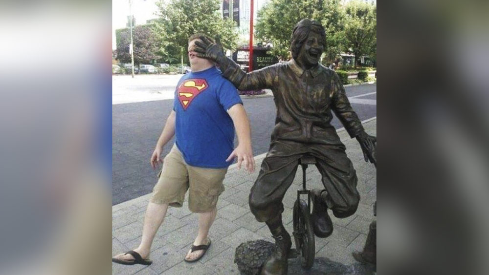 পথেঘাটে বহু লোককে সাইকেলে যাতায়াত করতে দেখা যায়। ছবিতে দেখা যাচ্ছে, সাইকেলে বসে থাকা ব্যক্তি নিজের খেয়ালে এমন ভাবে হাত ছড়িয়েছেন যে, তা পিছন থেকে আসা ব্যক্তির মুখে যেন আঘাত করেছে। আসলে সাইকেলচালকের মূর্তিটি পাথরের তৈরি। পিছনের লোকটি মজা করেই এমন পোজ দিয়েছেন।