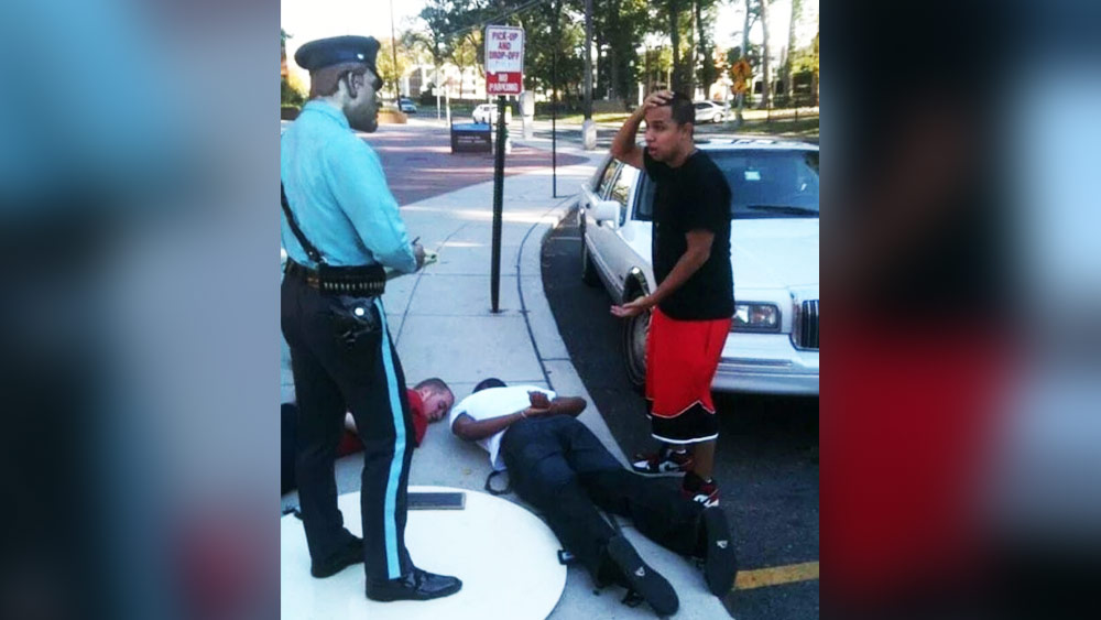 এই ছবিটি দেখে মনে হচ্ছে যেন রাস্তার কোনও দুর্ঘটনা ঘটে গিয়েছে। দাঁড়িয়ে থাকা ব্যাক্তিটি পুলিশকে ঘটনার বিবৃতি দিচ্ছেন। ফুটপাতে যে দু’জন হাত পিছন দিকে করে শুয়ে রয়েছেন, তাঁরাও এই ঘটনার সঙ্গে জড়িত। কিন্তু এই ছবিতে যে পুলিশকে দেখতে পাওয়া যাচ্ছে তা আসলে পাথরের মূর্তি। বাকি তিন জন পোজ দিয়ে এই ছবি তুলেছেন।