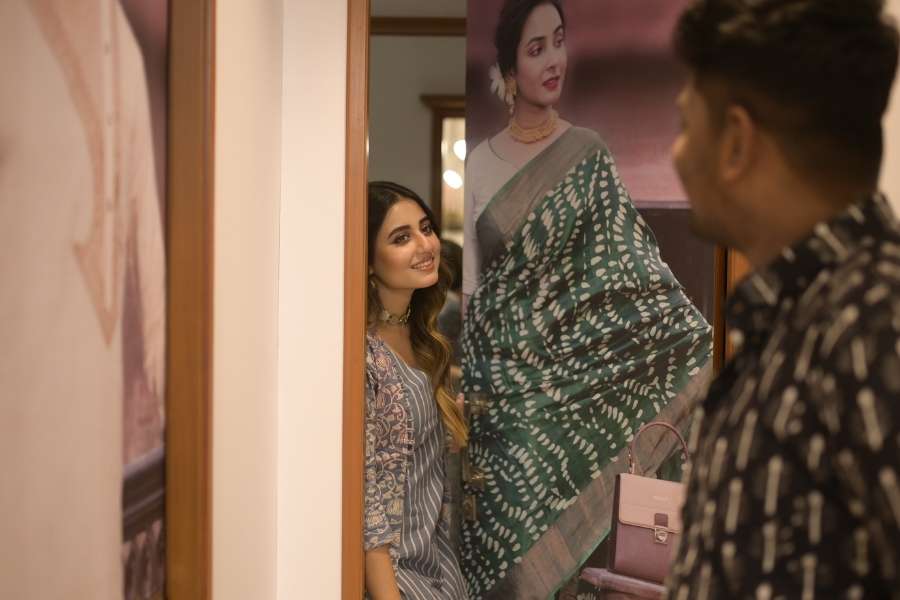 আকাশ নীল স্ট্রাইপ ড্রেসে, কলমকারি জ্যাকেটে ট্রায়াল রুমের বাইরে নায়িকা। শোভন কী বলছে, তার অপেক্ষায়।