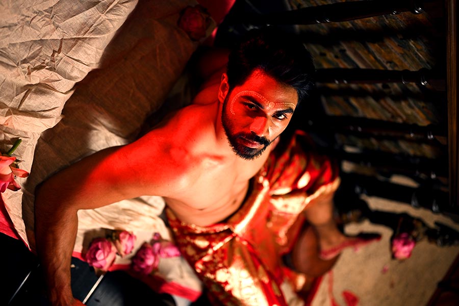 খোলা বুক, নিম্নাঙ্গে ধুতির মতো জড়িয়ে লাল টুকটুকে বেনারসি। পুজোর আগে এমনই সাজে সেজে উঠেছেন আতিফ।