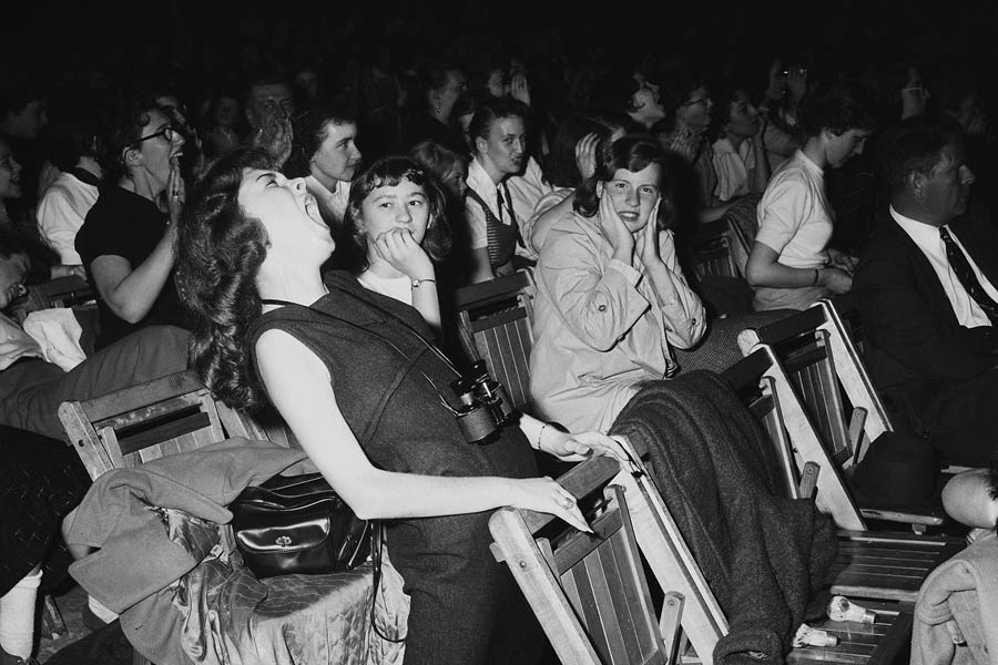 এলভিস প্রেসলির অনুষ্ঠানে তাঁর অনুরাগীরা কী রকম আচরণ করতেন? তার ঝলক মেলে এই ছবিতে। ১৯৫৭ সালের ৬ এপ্রিল ফিলাডেলফিয়া এরিনার মঞ্চ মাতিয়েছিলেন এলভিস। সে সময় প্রিয় গায়কের সঙ্গে সজোরে কণ্ঠ ছেড়েছিলেন তাঁর কিশোরী ভক্ত।