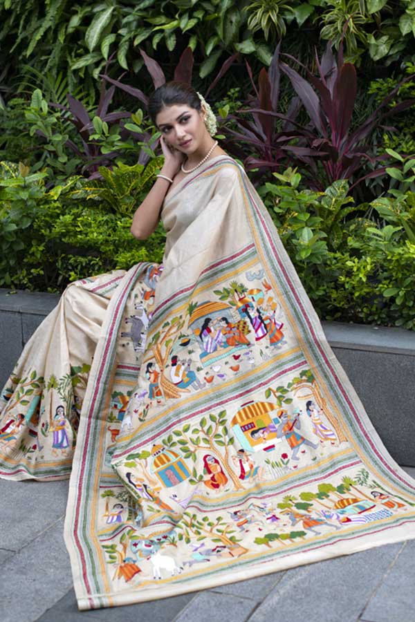 বেজ রঙের উপরে নানা রঙে আঁকা ‘নকশি কাঁথা’ নাকি পটচিত্র?  যেন আজও পরস্পরের দিকে তাকিয়ে তাদের ভালবাসার দিনগুলোকে মনে করে। এই শা়ড়িতে সৌরসেনীর মনেও প্রথম প্রেমের নস্ট্যালজিয়া।