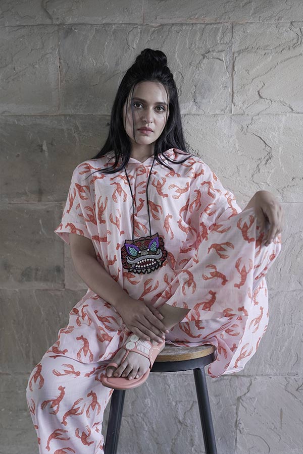 গলায় আদিবাসী নকশার বড় ঝোলা হার আর পায়ে প্যাস্টেল গোলাপি কাজের ম্যাচিং জুতো। একেবারে মানানসই অনুষঙ্গ। 