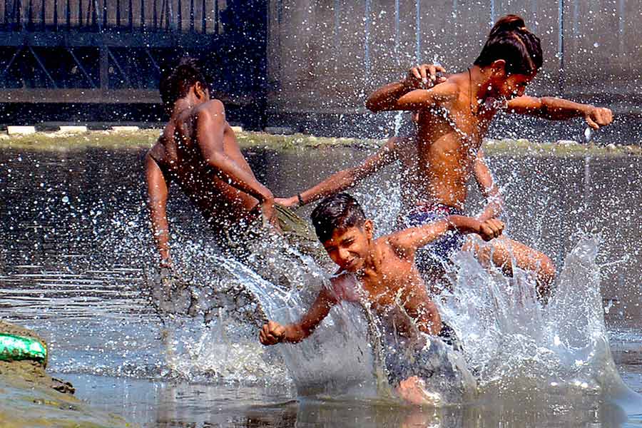 Children bathing in pond to get relief from intense heat