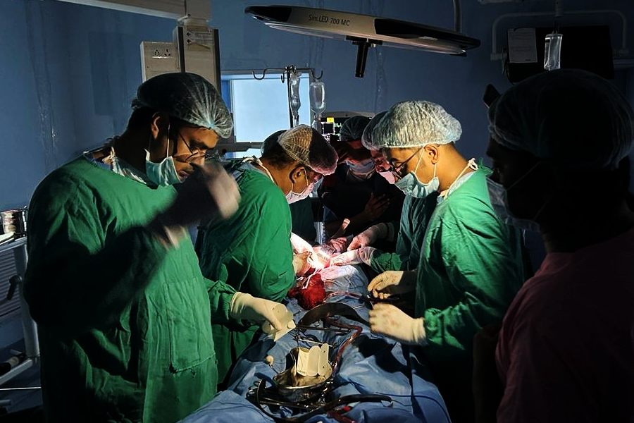A team of doctors in Medical College operates a patient in mobile flash light