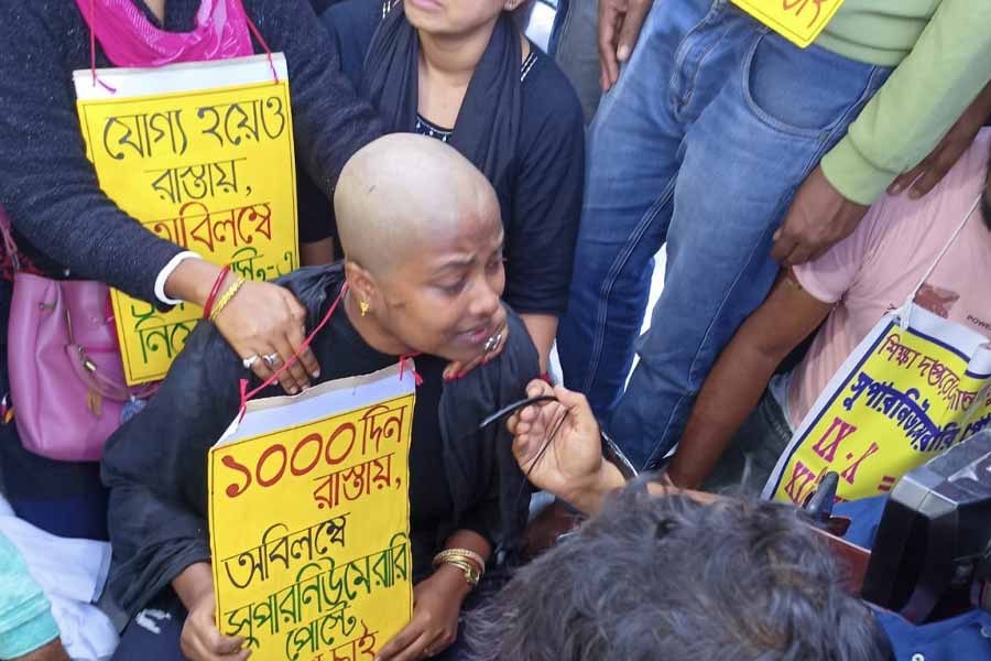 গান্ধীমূর্তির পাদদেশে মাথা মুড়িয়ে প্রতিবাদ রাসমণি পাত্রের।