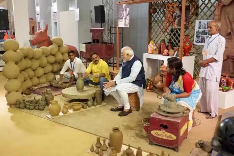 বিশ্বকর্মার কর্মকাণ্ড। দিল্লির যশোভূমিতে বিশ্বকর্মা পুজোর দিন ঘোষণা করা হয় প্রধানমন্ত্রী বিশ্বকর্মা যোজনা। বিভিন্ন হস্তশিল্পের সঙ্গে যুক্ত শিল্পীদের বিশ্বকর্মা নাম দিয়ে তাঁদের সরকারি সাহায্যের প্রকল্প। ছবিতে তেমনই এক বিশ্বকর্মার পাশে বসে কাজ দেখছেন মোদী।  