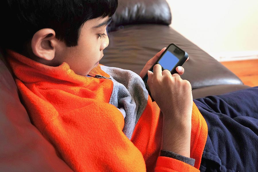 Picture of a boy using smartphone.