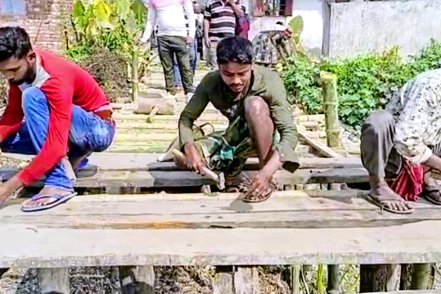 Youths from Bhangar repairing wooden bridge