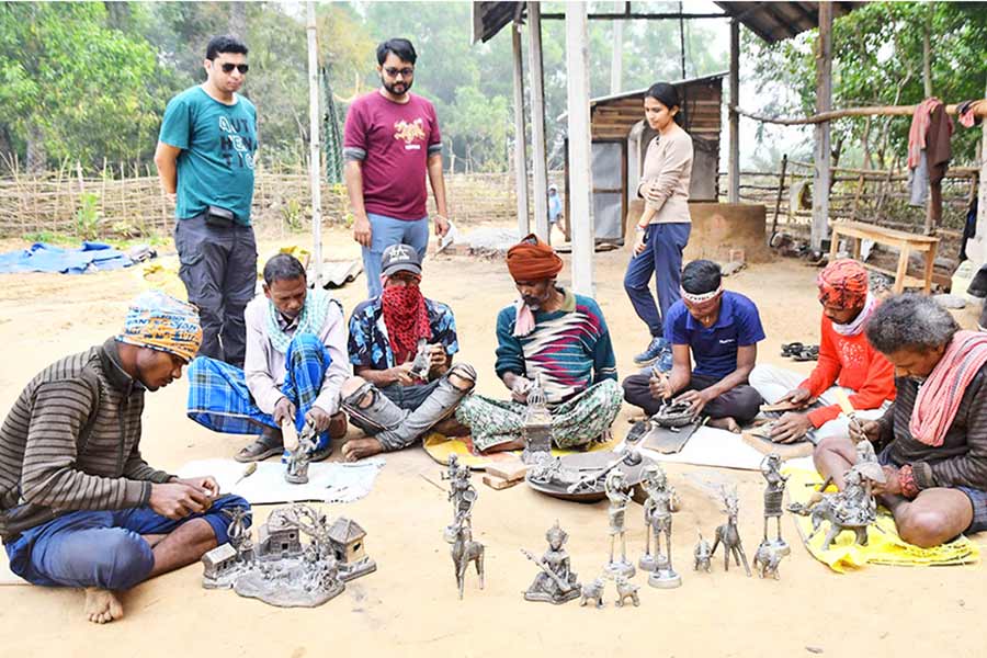 ডোকরা শিল্পকর্ম তৈরি দেখছেন পর্যটকেরা। নিজস্ব চিত্র