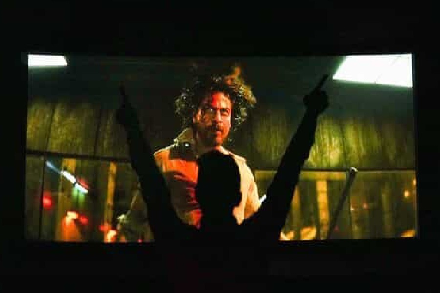 A photograph of Pathaan movie being watched in Theatre.