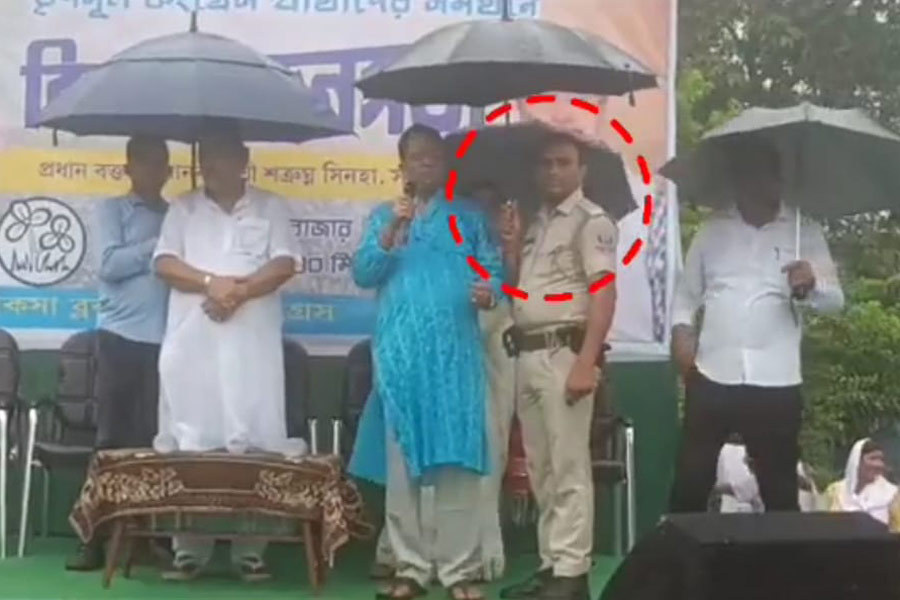 Police holding umbrella for TMC leader